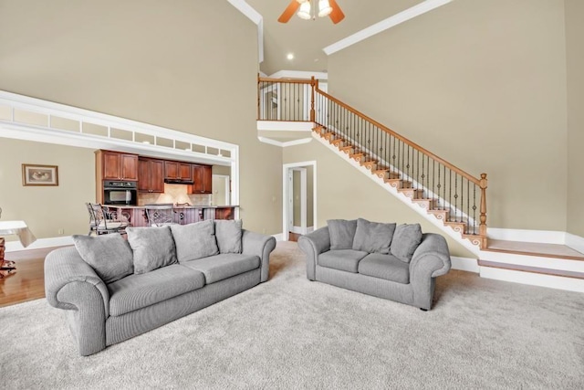 2740 Heritage Bend Ct SW, Grayson, GA 30017 - carpeted living room with a high ceiling, ceiling fan, stairway, ornamental molding, and baseboards