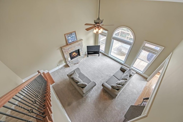 2740 Heritage Bend Ct SW, Grayson, GA 30017 - carpeted living room with a towering ceiling, a fireplace, a ceiling fan, and baseboards
