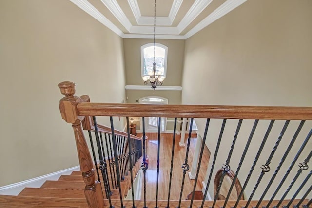 2740 Heritage Bend Ct SW, Grayson, GA 30017 - staircase featuring a chandelier, ornamental molding, wood finished floors, baseboards, and a tray ceiling