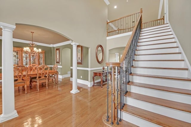 2740 Heritage Bend Ct SW, Grayson, GA 30017 - staircase featuring arched walkways, wood finished floors, ornamental molding, baseboards, and a high ceiling