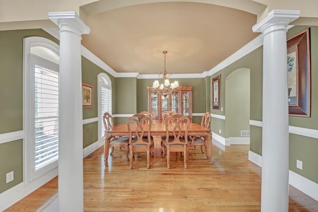 2740 Heritage Bend Ct SW, Grayson, GA 30017 - dining area with ornate columns, light wood finished floors, a chandelier, crown molding, and baseboards