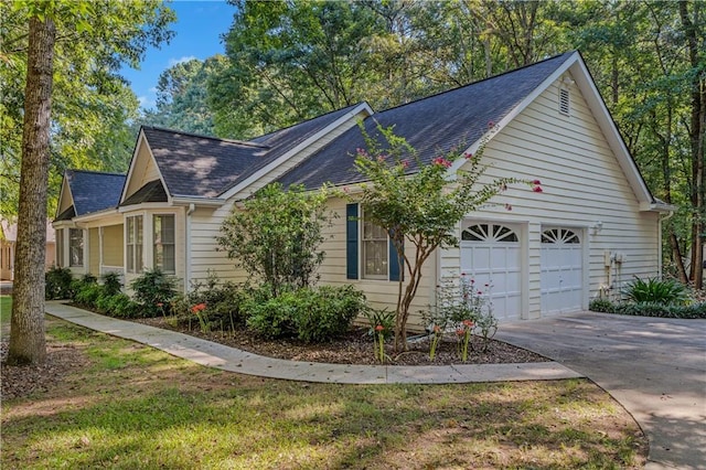 view of home's exterior with driveway, an attached garage, and a shingled roof