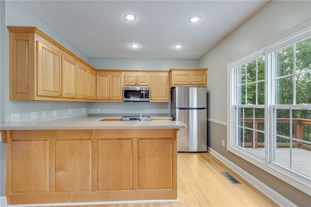 4039 Sargent Cir, Gainesville, GA 30506 - kitchen with stainless steel appliances, light brown cabinets, baseboards, a peninsula, and light wood-style flooring