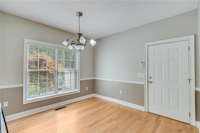 4039 Sargent Cir, Gainesville, GA 30506 - unfurnished dining area featuring a chandelier, light wood-style flooring, a textured ceiling, and baseboards