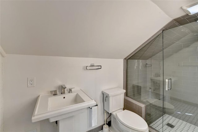 bathroom featuring vaulted ceiling, toilet, a shower stall, and a sink