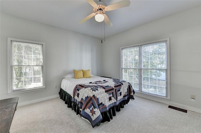 carpeted bedroom featuring visible vents, ceiling fan, and baseboards