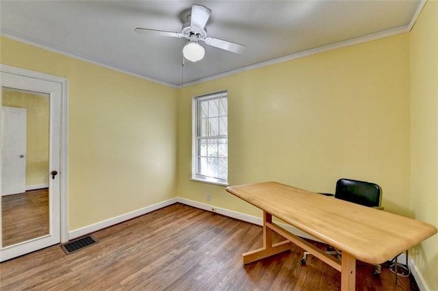 office area featuring baseboards, wood finished floors, visible vents, and ornamental molding