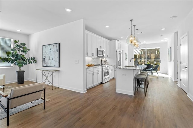 388 Pratt Dr Unit 2113, Atlanta, GA 30315 - kitchen with stainless steel appliances, a breakfast bar area, healthy amount of natural light, an island with sink, and recessed lighting