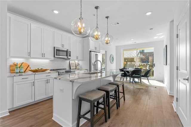 388 Pratt Dr Unit 2113, Atlanta, GA 30315 - kitchen featuring appliances with stainless steel finishes, a chandelier, a center island with sink, white cabinets, and recessed lighting