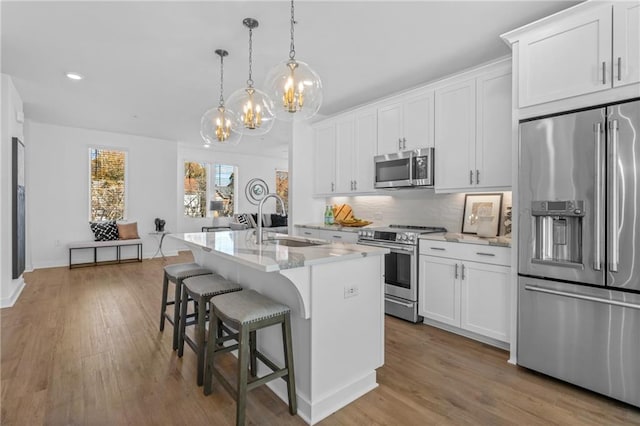 388 Pratt Dr Unit 2113, Atlanta, GA 30315 - kitchen featuring appliances with stainless steel finishes, a chandelier, a kitchen breakfast bar, a kitchen island with sink, and wood finished floors