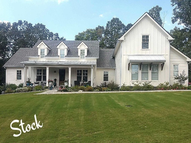 view of front of house featuring board and batten siding, covered porch, a front lawn, and a standing seam roof