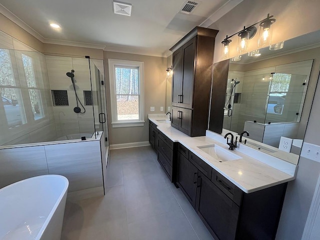 bathroom with a stall shower, a freestanding bath, double vanity, crown molding, and baseboards