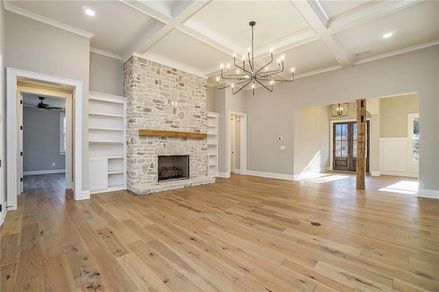 unfurnished living room with a chandelier, coffered ceiling, light wood-style floors, beamed ceiling, and a fireplace