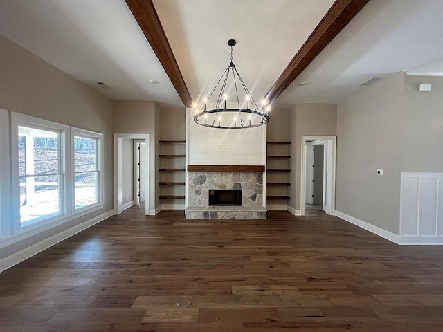 unfurnished living room featuring beamed ceiling, a chandelier, baseboards, dark wood finished floors, and a fireplace