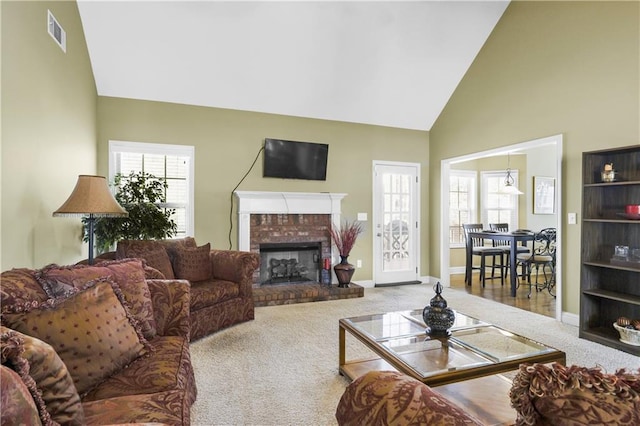 living room with a fireplace, carpet floors, high vaulted ceiling, and a wealth of natural light