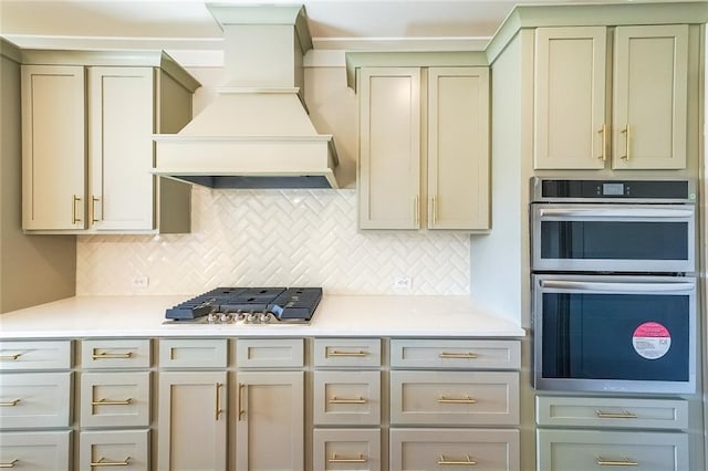 kitchen with backsplash, premium range hood, light countertops, and stainless steel appliances