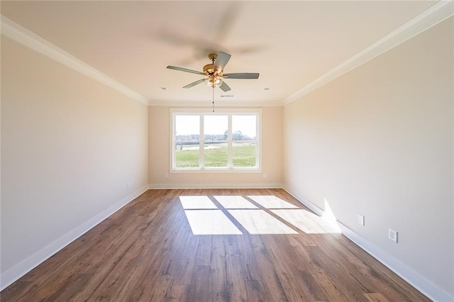 empty room with ceiling fan, crown molding, baseboards, and wood finished floors