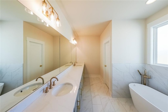 bathroom featuring marble finish floor, double vanity, and a sink