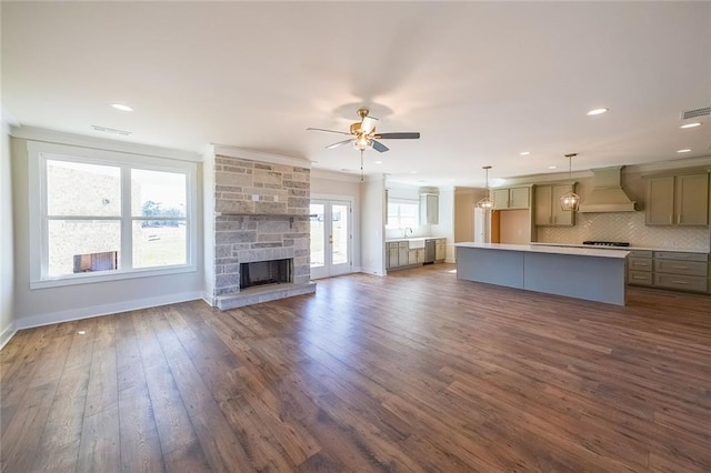 unfurnished living room featuring dark wood-style flooring, a fireplace, visible vents, a ceiling fan, and baseboards