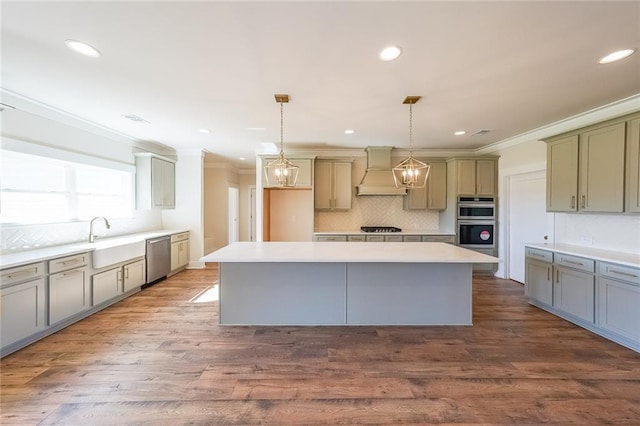 kitchen featuring premium range hood, a kitchen island, pendant lighting, and light countertops