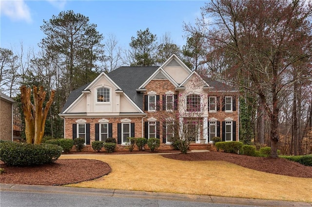 view of front of house featuring brick siding and a front lawn