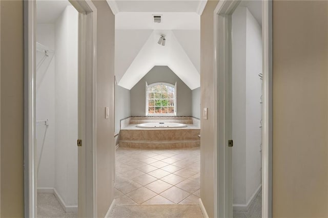 full bathroom featuring tile patterned floors, visible vents, lofted ceiling, and a garden tub