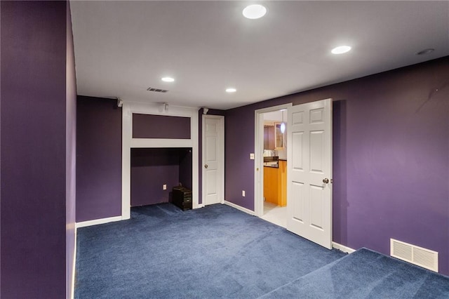 unfurnished bedroom featuring visible vents, baseboards, and dark colored carpet