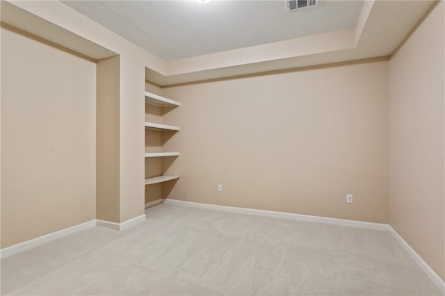 unfurnished room with visible vents, light colored carpet, and baseboards