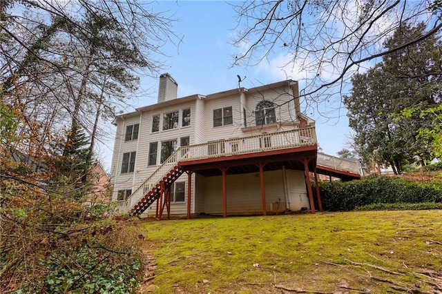 back of house featuring a deck, stairway, a lawn, and a chimney