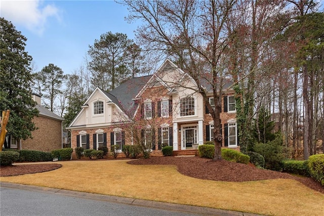 view of front of house with brick siding and a front yard