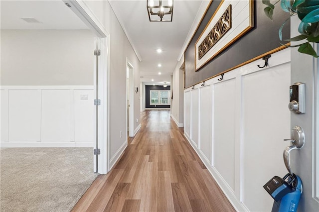 hallway featuring light hardwood / wood-style floors and an inviting chandelier