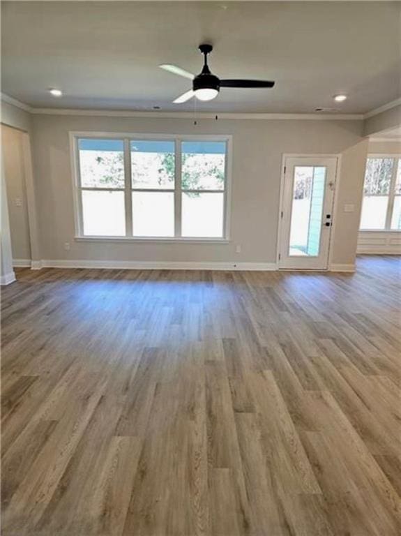 1695 Crumbley Rd, Mcdonough, GA 30252 - unfurnished living room featuring baseboards, crown molding, wood finished floors, a ceiling fan, and recessed lighting