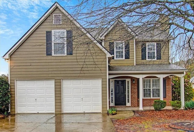 traditional home with a garage, brick siding, covered porch, and driveway