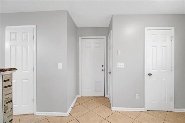 entrance foyer featuring light tile patterned floors and baseboards