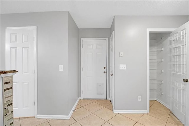 entryway featuring light tile patterned floors and baseboards