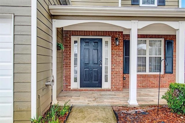 property entrance with a garage and brick siding