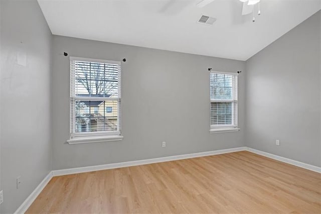 unfurnished room featuring visible vents, light wood-style floors, baseboards, ceiling fan, and vaulted ceiling