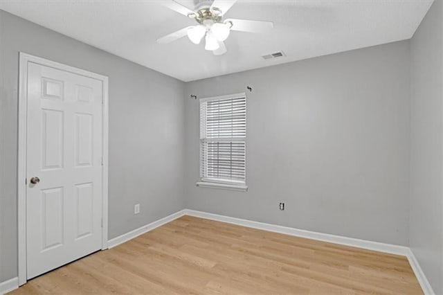 unfurnished room with ceiling fan, baseboards, visible vents, and light wood-type flooring