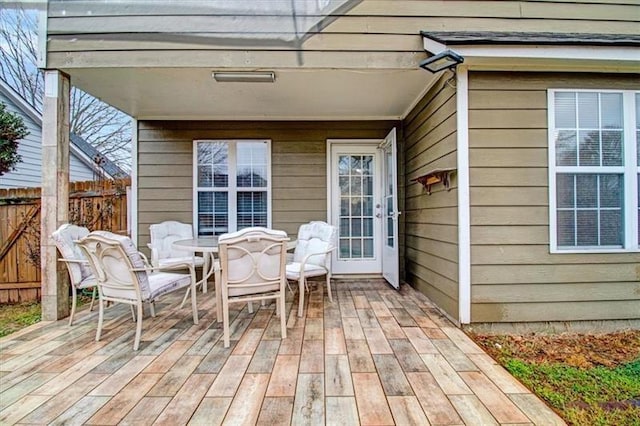 deck with outdoor dining area and fence