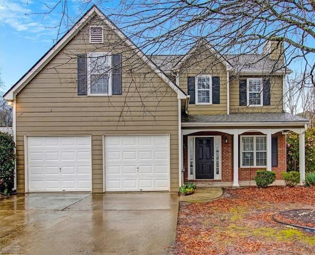 traditional-style home featuring brick siding, a porch, a chimney, driveway, and an attached garage