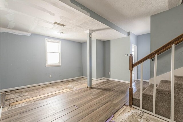 basement with hardwood / wood-style flooring and a textured ceiling