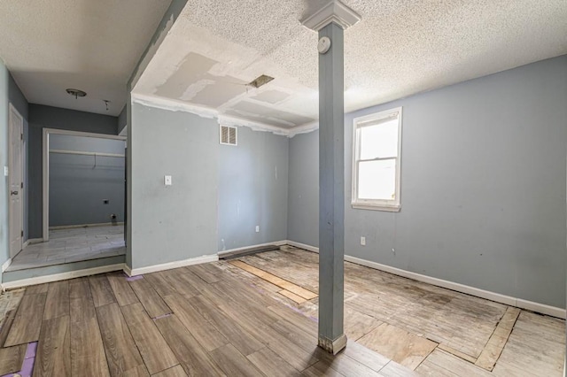 interior space featuring a textured ceiling and light hardwood / wood-style flooring