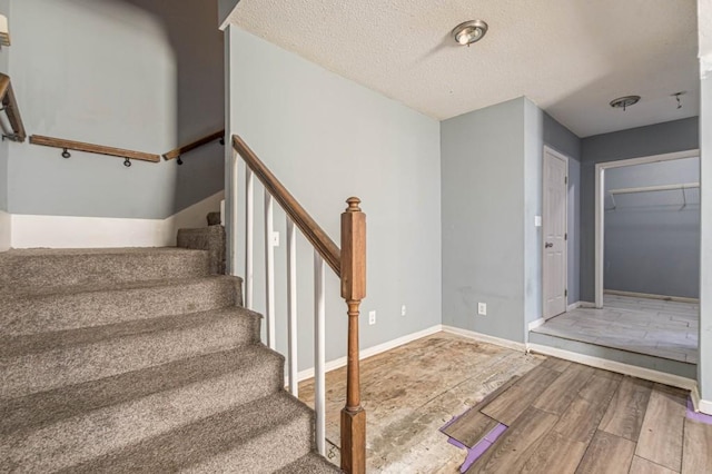 stairs featuring a textured ceiling