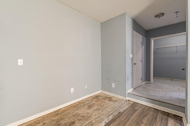 interior space featuring light hardwood / wood-style floors, a textured ceiling, and a closet