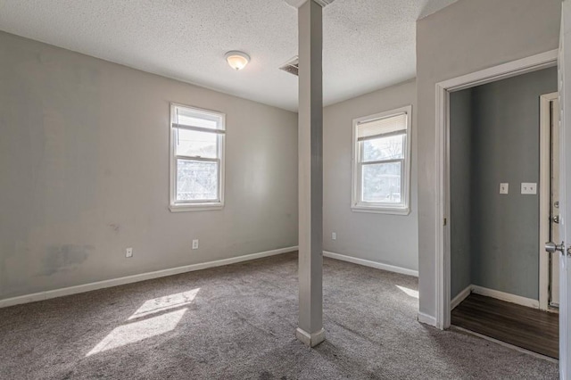 carpeted empty room with a textured ceiling