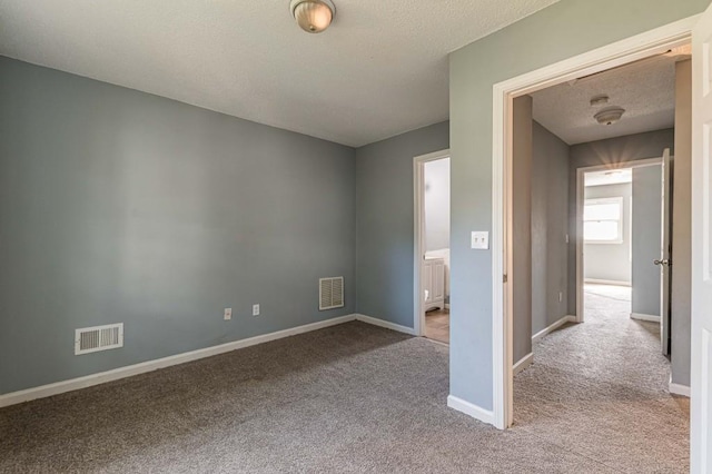 unfurnished bedroom featuring a textured ceiling and light colored carpet