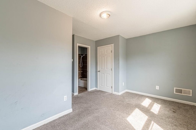 unfurnished room featuring carpet flooring and a textured ceiling