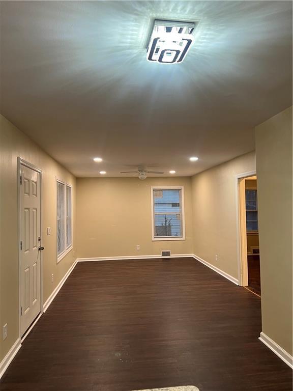 empty room featuring dark wood-type flooring and ceiling fan