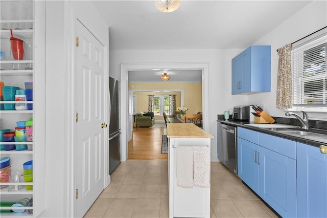 511 Robinson Ave SE, Atlanta, GA 30315 - kitchen featuring appliances with stainless steel finishes, a sink, blue cabinets, and light tile patterned floors