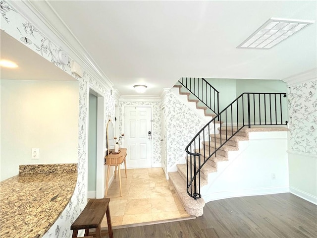 foyer entrance with hardwood / wood-style flooring and crown molding